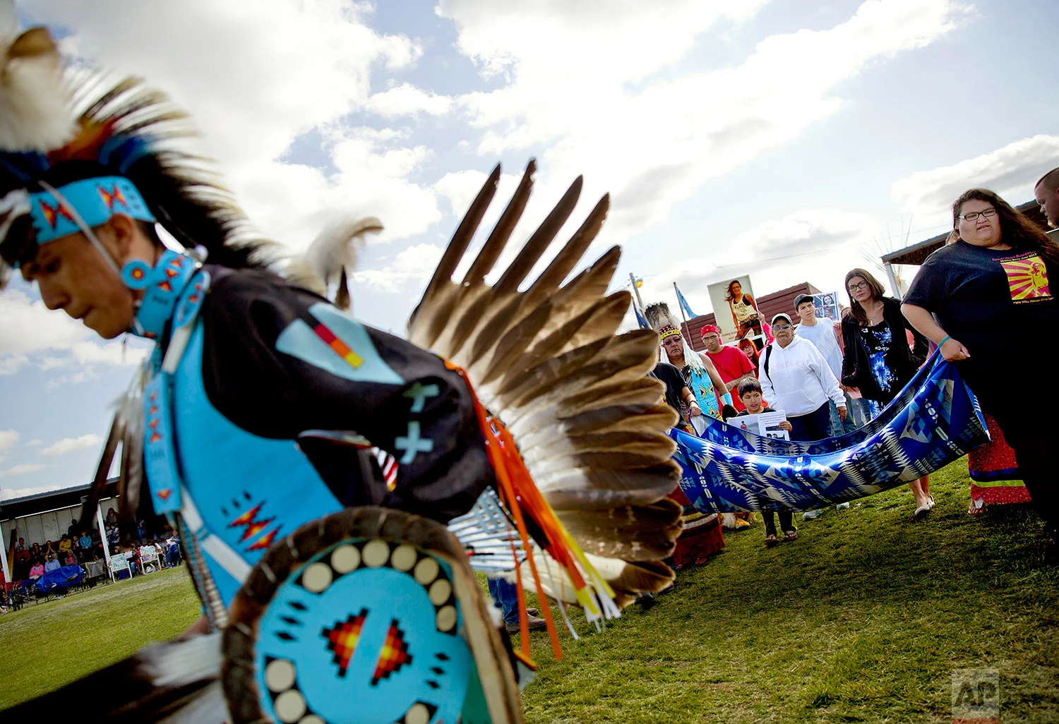 Friends and family members of Ashley HeavyRunner Loring hold a traditional blanket dance before the crowd at the North American Indian Days celebration to raise awareness and funds for her search on the Blackfeet Indian Reservation in Browning, Mont., July 14, 2018. (AP Photo/David Goldman)