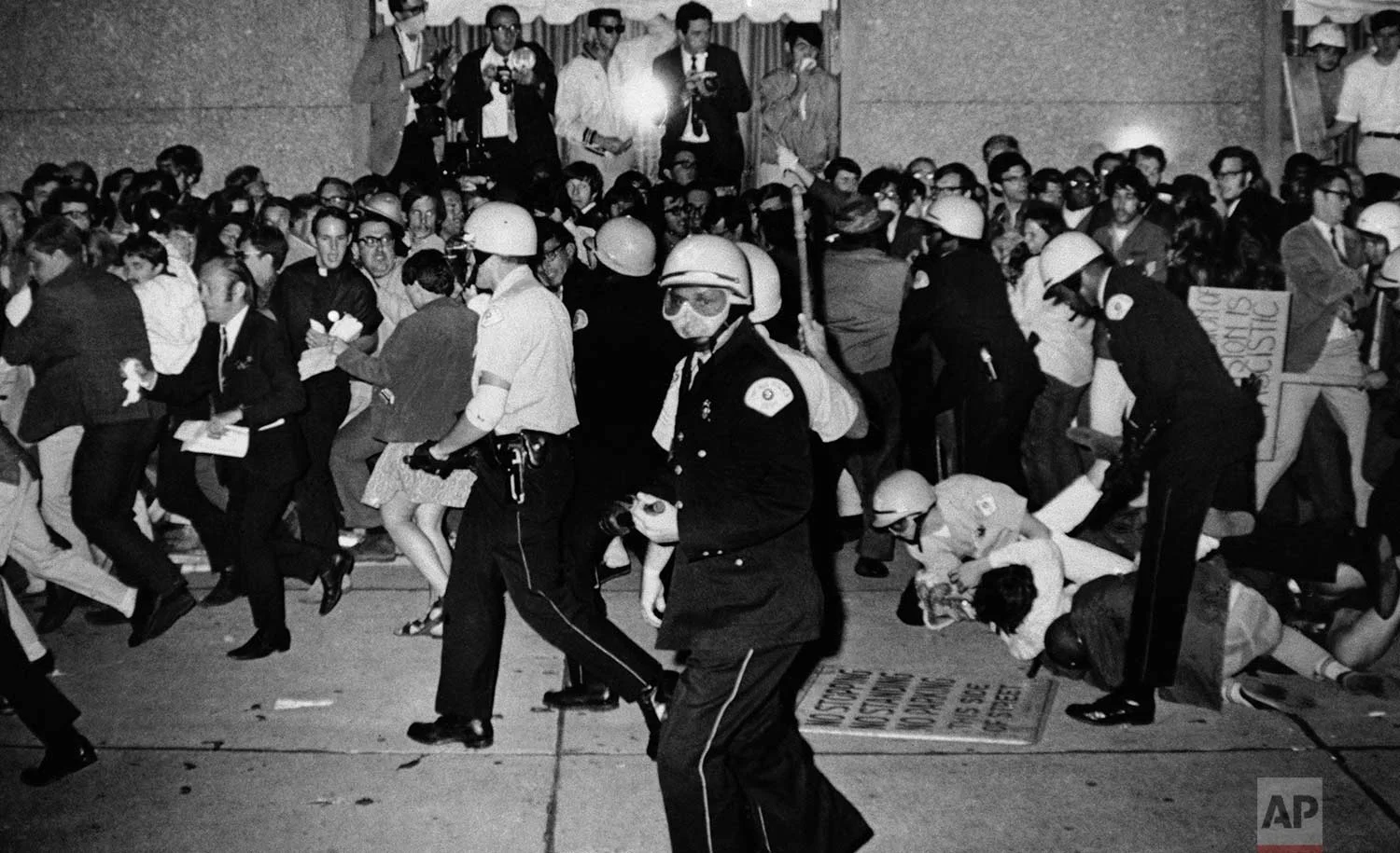 Jeers greet Chicago Police Aug. 29, 1968 as they attempt to disperse demonstrators outside the Conrad Hilton, Democratic National Convention headquarters in Chicago. Some police struggle with several demonstrators on the sidewalk. (AP Photo/Michael Boyer)
