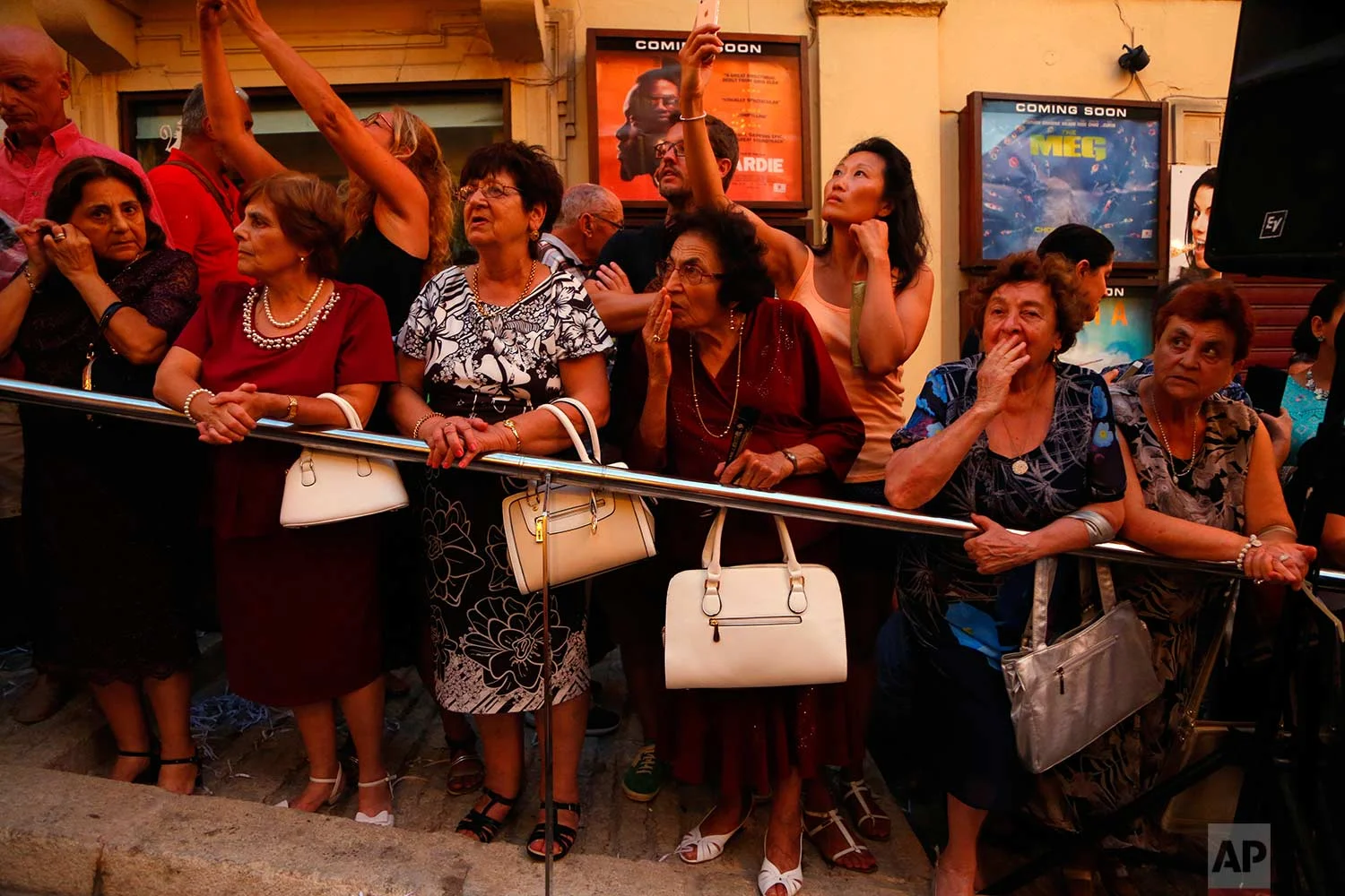 In this photo taken on Wednesday, Aug. 15, 2018, local women blow kisses and look at the statue of the Virgin Mary during a procession on the feast of the Assumption of Our Lady in Rabat on the island of Gozo in the Maltese archipelago. (AP Photo/Niranjan Shrestha)