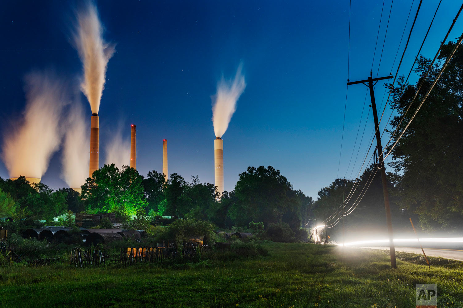 The John E. Amos Power Plant is seen from a field outside of Winfield, W. Va., on Thursday night, Aug. 23, 2018. Built in the 1970's, the coal-fired facility is the largest in the American Electric Power company's portfolio. Many of AEP's smaller coal-fired power plants in Appalachia closed in response to environmental regulations such as the Clean Power Plan in 2015. (Craig Hudson/Charleston Gazette-Mail via AP)