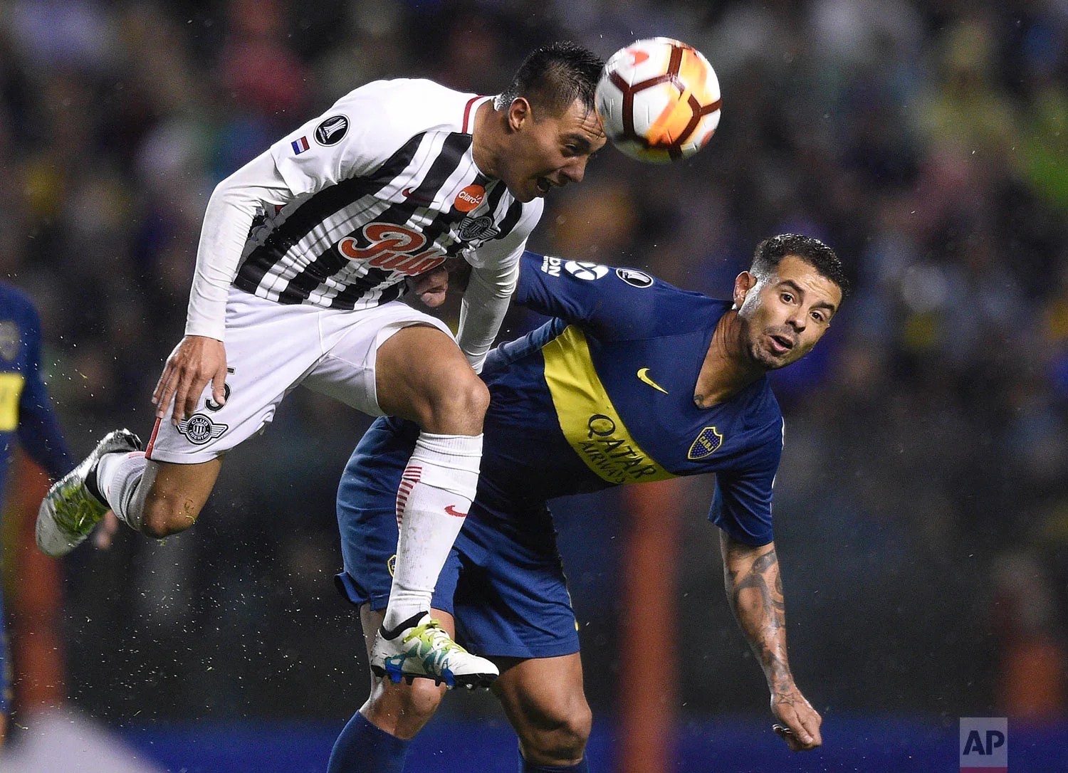 Angel Lucena of Paraguay's Libertad, left, heads the ball alongside Edwin Cardona Argentina's Boca Juniors during a Copa Libertadores soccer match in Buenos Aires, Argentina, Aug. 8, 2018. (AP Photo/Gustavo Garello)