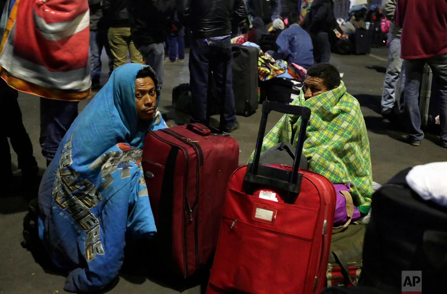 Venezuelan migrants wait for a decision from immigration authorities that allows them to enter Ecuador without a passport after the deadline passed on new regulations that demand passports from migrants, in Rumichaca, Ecuador, Aug. 18, 2018. The United Nations estimates 2.3 million Venezuelans have fled since 2014, the majority of them going to Colombia or Peru.(AP Photo/Dolores Ochoa)
