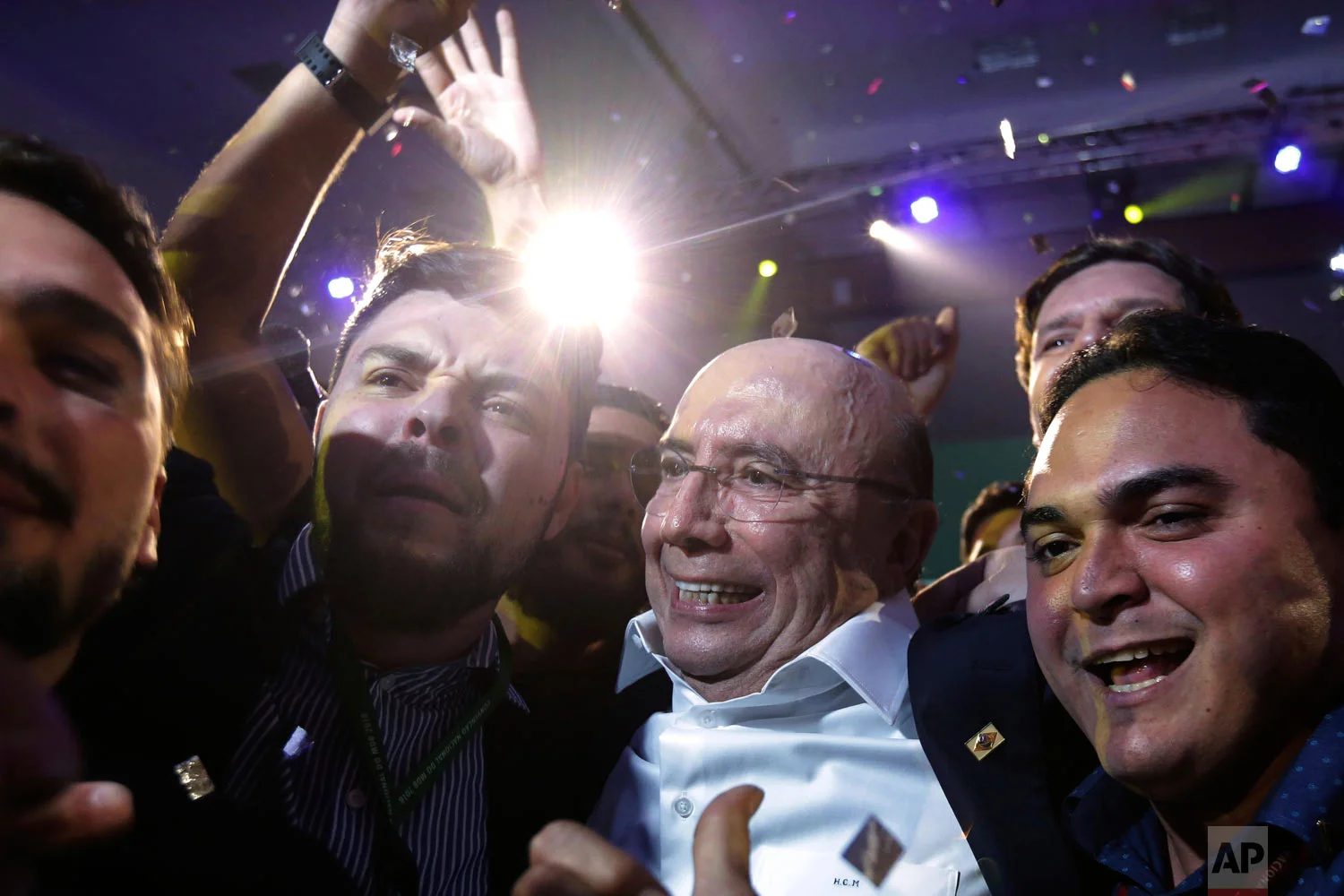 Brazil's former finance minister Henrique Meirelles, center, celebrates with supporters at the end of The Brazilian Democratic Movement party convention, in Brasilia, Brazil, Aug. 2, 2018. The Brazilian Democratic Movement announced Meirelles as its candidate for the upcoming October election. (AP Photo/Eraldo Peres)
