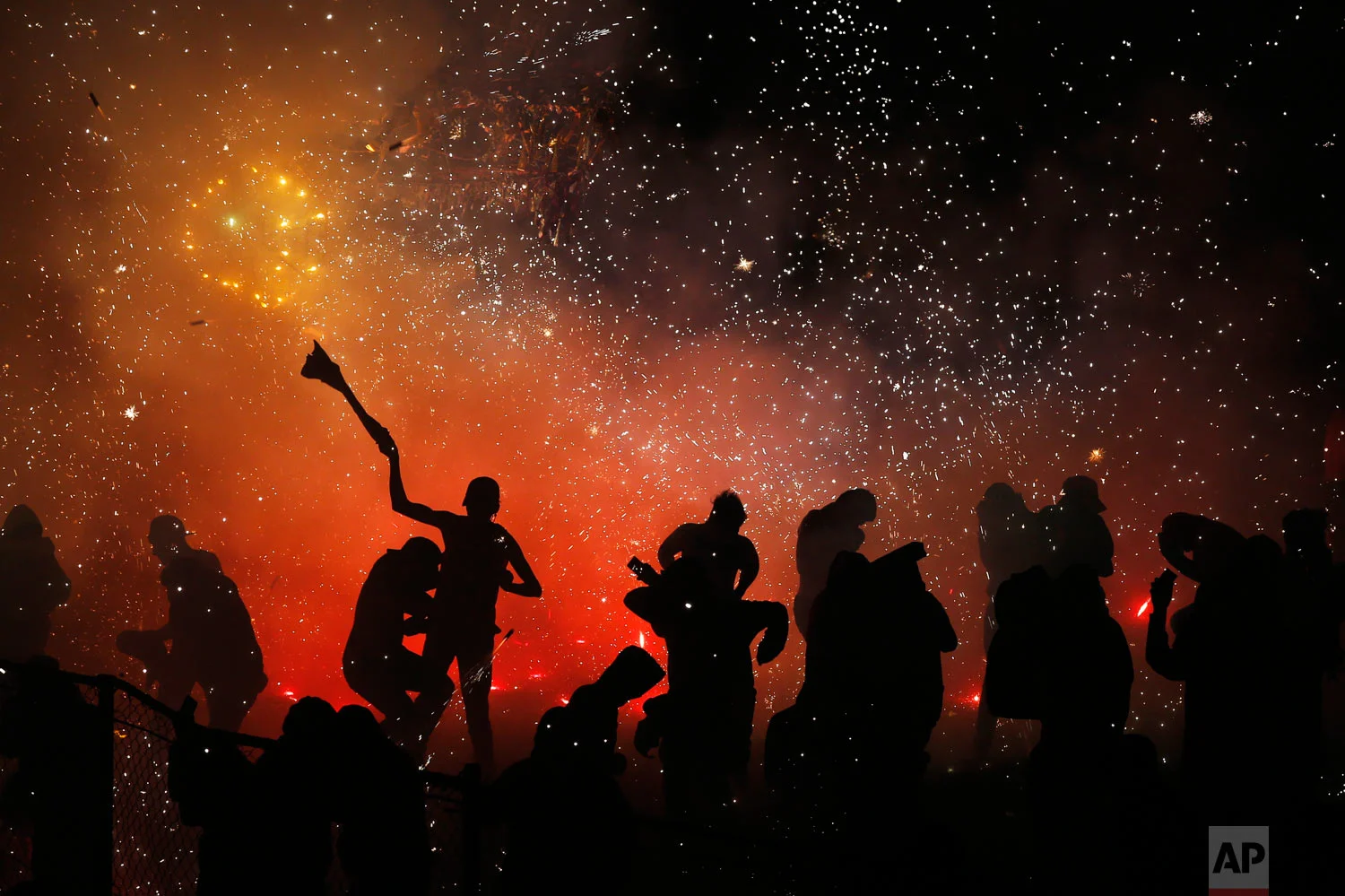 In this July 30, 2018 photo published in August, revelers play in and around a huge burning papier mache bull full of exploding fireworks, in the Santiago Teyuhalco neighborhood of Tultepec, Mexico. Last year there were 40 fireworks accidents in the State of Mexico, where Tultepec is located, that claimed 24 lives and injured more than 100, according to the governmental Mexican Institute of Pyrotechnics; through July 5 of this year, there have been 16 accidents with 40 dead and more than 70 hurt. (AP Photo/Marco Ugarte)