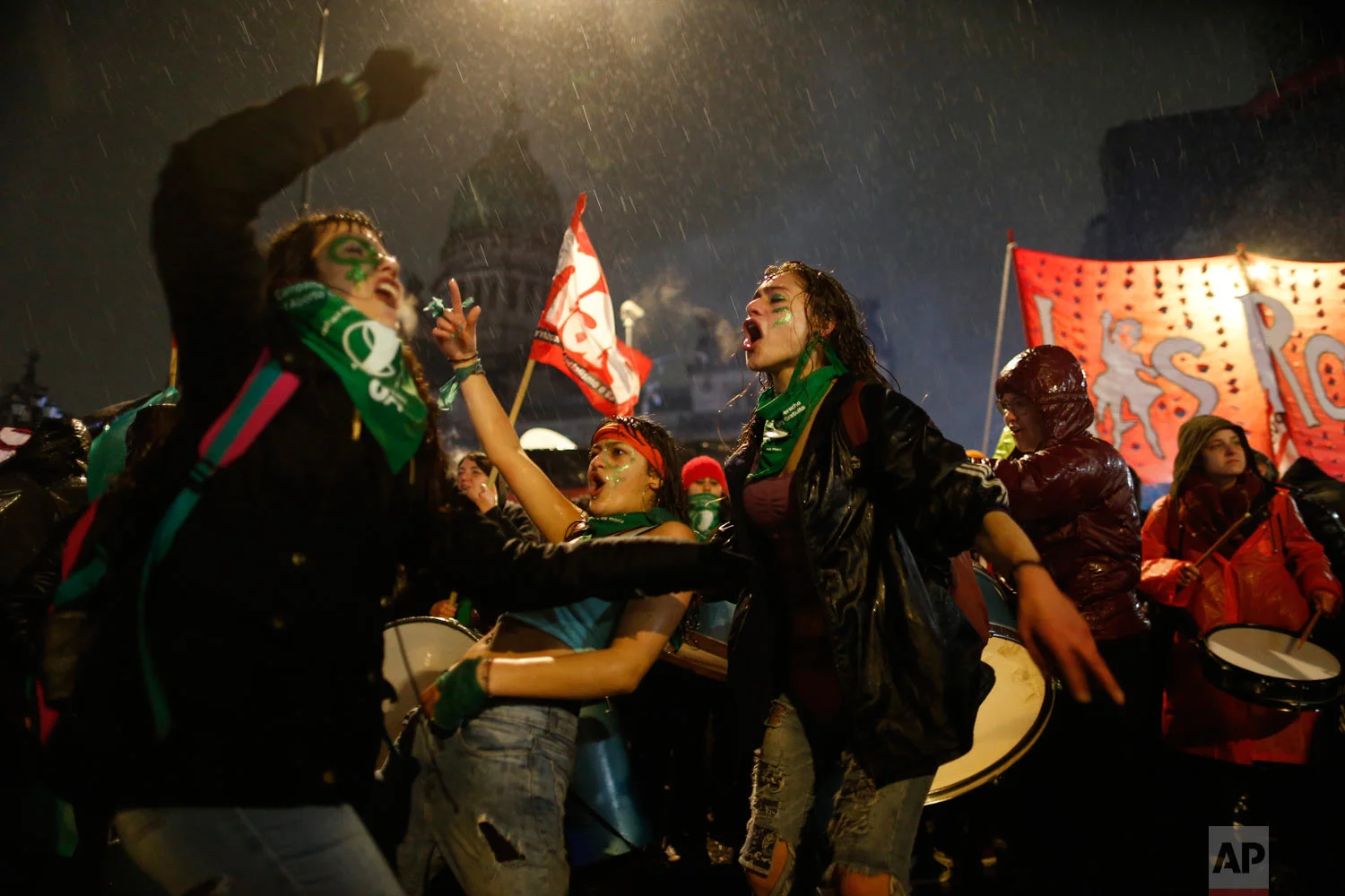 Women in support of decriminalizing abortion protest in the rain outside Congress where lawmakers are debating the issue in Buenos Aires, Argentina, Aug. 8, 2018. The Senate is debating a bill Wednesday that would legalize elective abortion in the first 14 weeks of pregnancy in the homeland of Pope Francis, setting up a vote that could reverberate around the region. (AP Photo/Natacha Pisarenko)