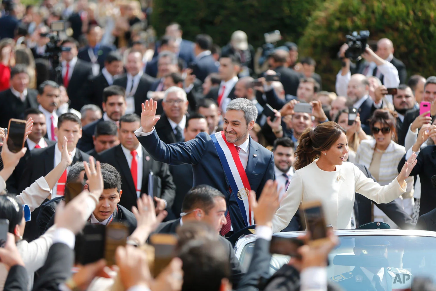 Paraguay's new President Mario Abdo Benitez rides in an open top car with his wife Silvana Lopez, after his inauguration ceremony at "Lopez Palace" in Asuncion, Paraguay, Aug. 15, 2018. (AP Photo/Jorge Saenz)