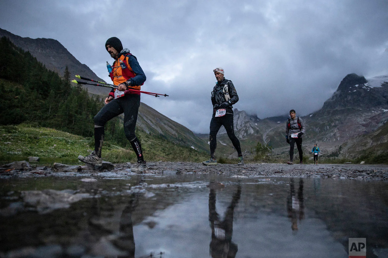Competitors run next to the Combal lake as they compete in the 170km Ultra-Trail of Mont-Blanc (UTMB) race, in Courmayeur, Italy, Sept 1, 2018. (AP Photo/Laurent Cipriani)