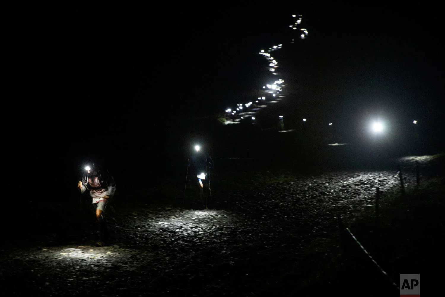 Competitors run along the Voza path as they compete in the 170km Ultra-Trail of Mont-Blanc (UTMB) race, in Saint Gervais-les- Bains, French Alps, Aug. 31, 2018. (AP Photo/Laurent Cipriani)