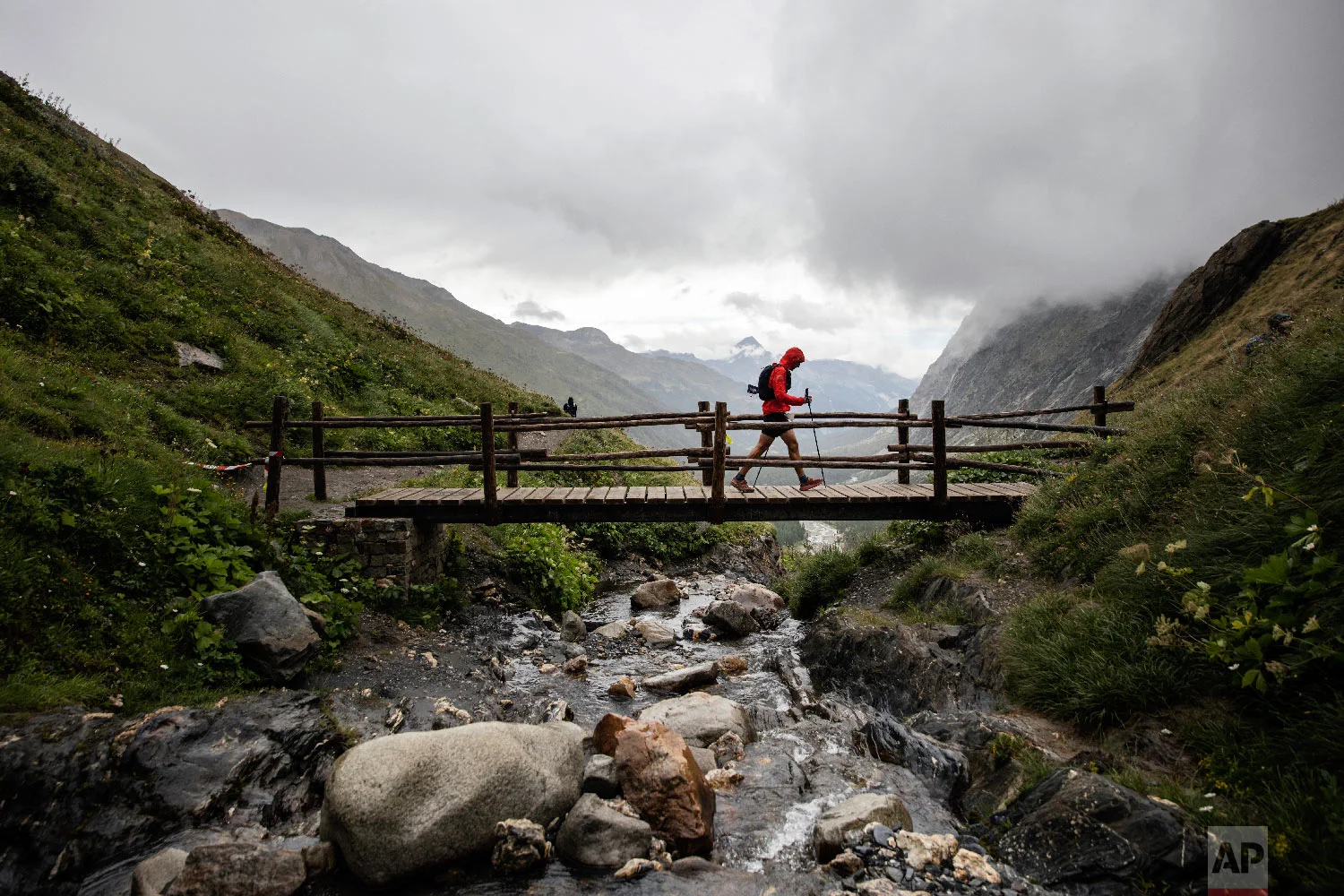 A competitor walks over a bridge on the Grand Col Ferret as he competes in the 170km Ultra-Trail of Mont-Blanc (UTMB) race, near Courmayeur, Italy, Sept 1, 2018. (AP Photo/Laurent Cipriani)