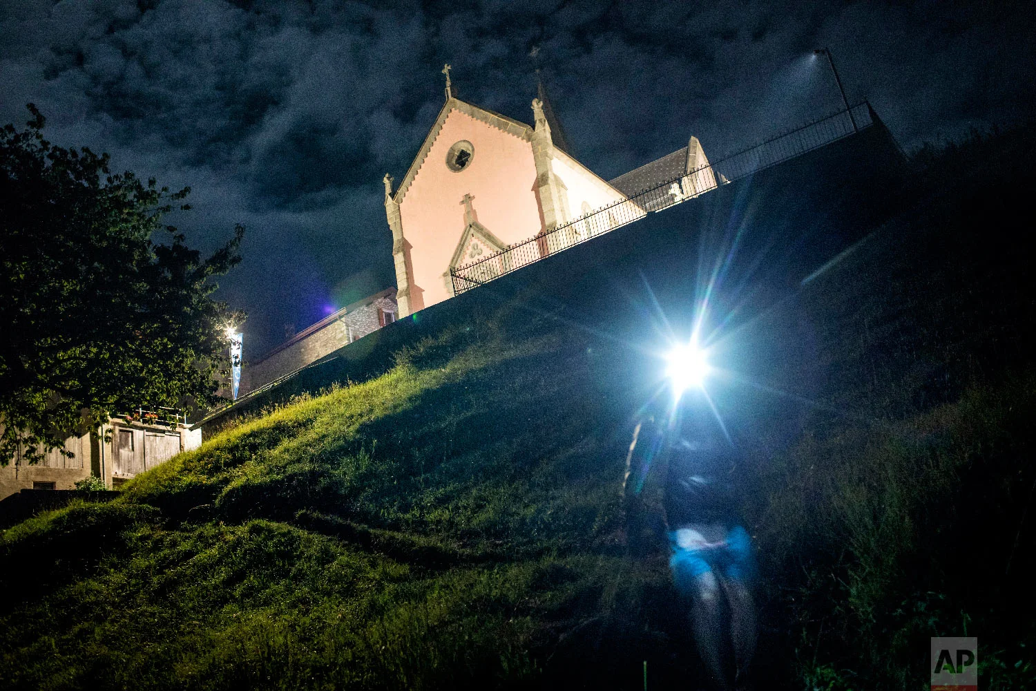 A competitor runs in the night in Trient, Switzerland, as he competes in the 170km Ultra-Trail of Mont-Blanc (UTMB) race, Sept 2, 2018. (AP Photo/Laurent Cipriani)