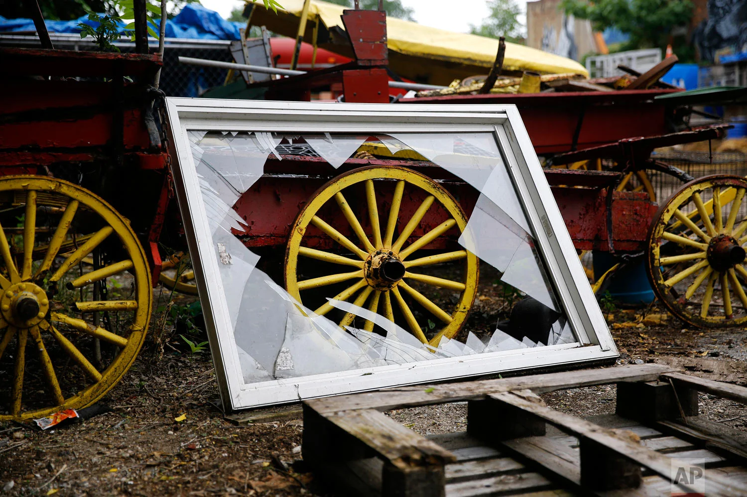 A broken window rests against a disused horse-drawn cart at an arabber stable in Baltimore in this June 18, 2018, photo. (AP Photo/Patrick Semansky)