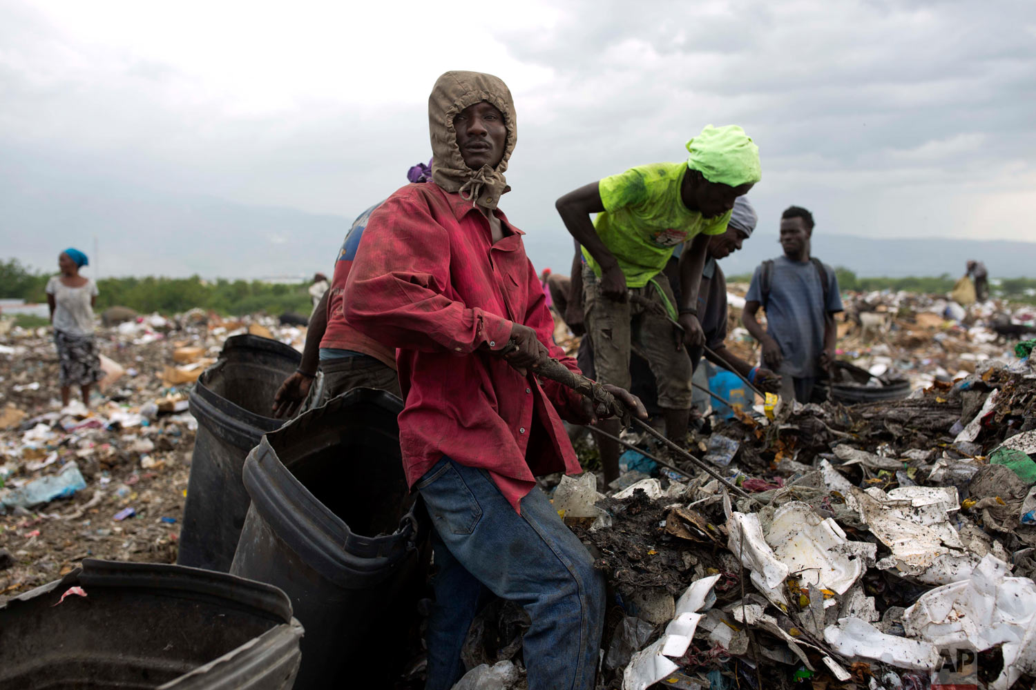  Changlair Aristide pauses as he picks through the trash with a metal rod. Aug. 23, 2018. (AP Photo/Dieu Nalio Chery) 