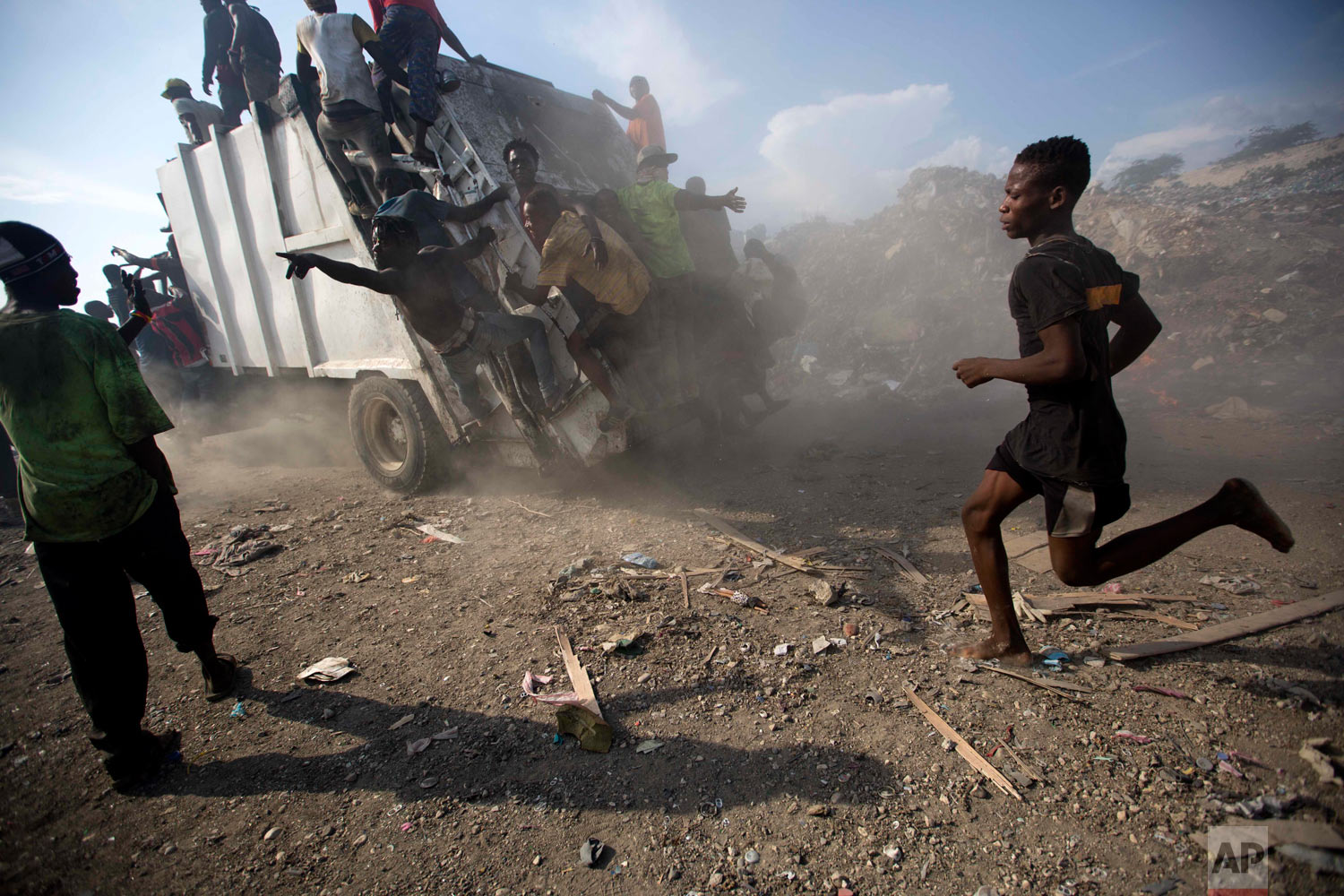 Scavengers climb on a trash truck arriving to unload at the landfill. Aug. 28, 2018. (AP Photo/Dieu Nalio Chery) 