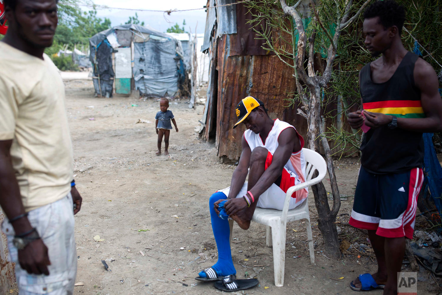  Changlair Aristide, who coaches a soccer team made up mostly of trash scavengers, gets ready to play a game. Aug. 29, 2018. (AP Photo/Dieu Nalio Chery) 