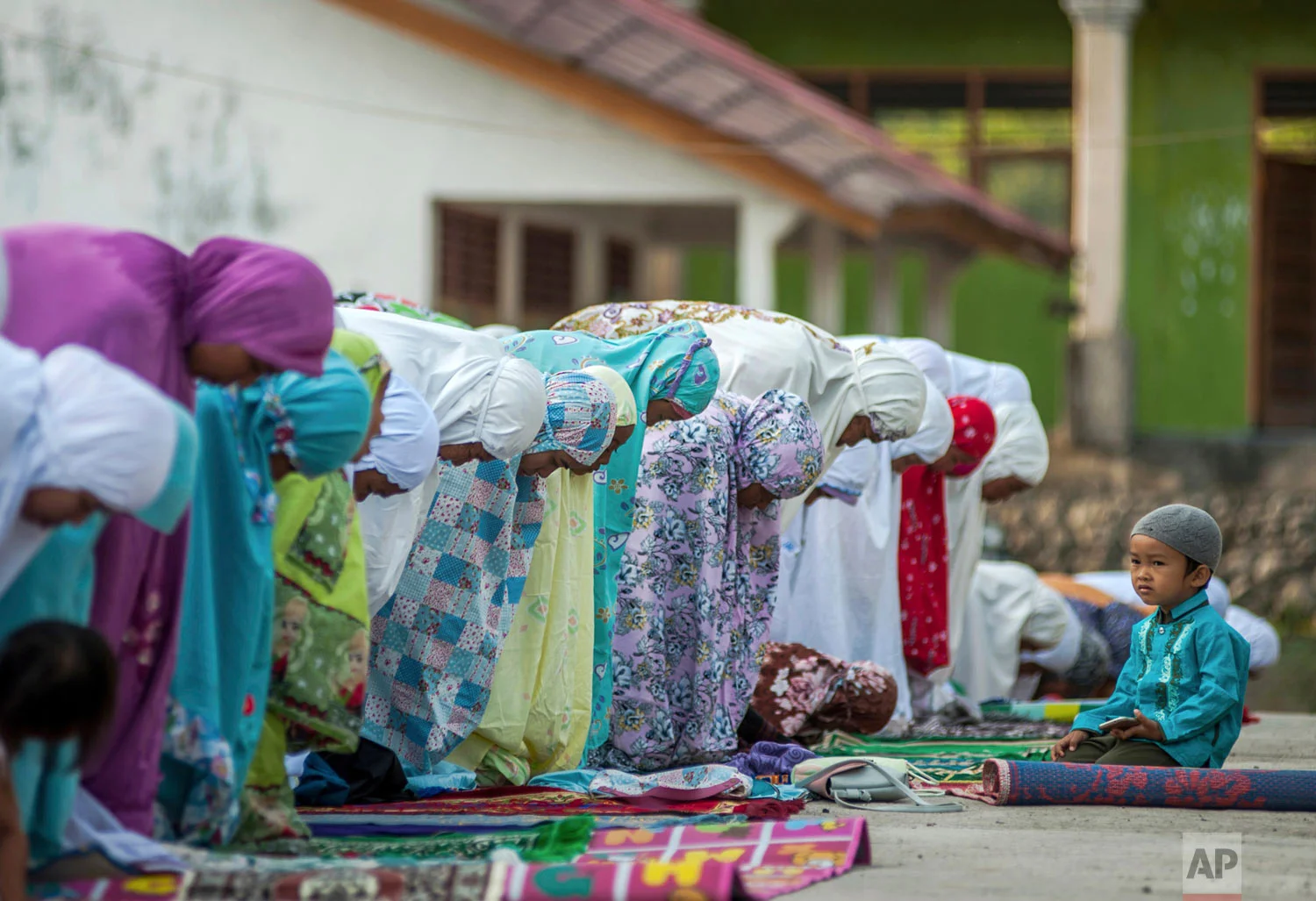 People who were affected by an earthquake attend a morning prayer session marking Eid al-Adha in Kokokputek, Lombok Island, Indonesia, Wednesday, Aug. 22, 2018. (AP Photo/Fauzy Chaniago)