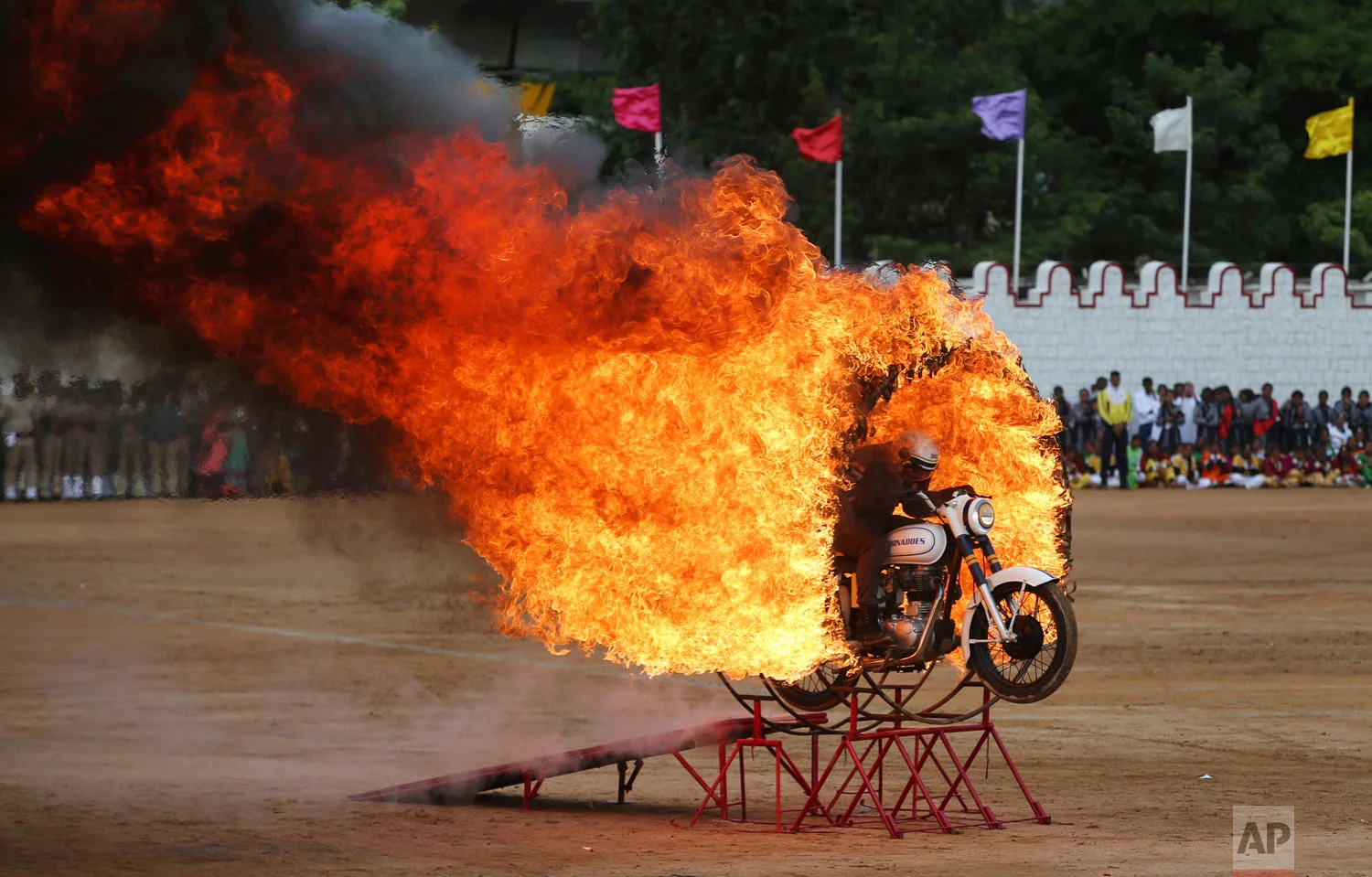 A member of ASC Tornados, the motorcycle display team of the Indian army, jumps through a fire ring as he performs a daredevil stunt during Indian Independence Day celebrations in Bangalore, India, Wednesday, Aug. 15, 2018. (AP Photo/Aijaz Rahi)