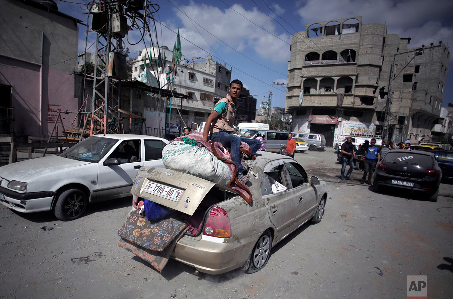  In this July 26, 2014 photo, Palestinians salvage what little of their belongings they could from their homes during a 12-hour cease-fire in Gaza City's Shijaiyah neighborhood. (AP Photo/Khalil Hamra) 