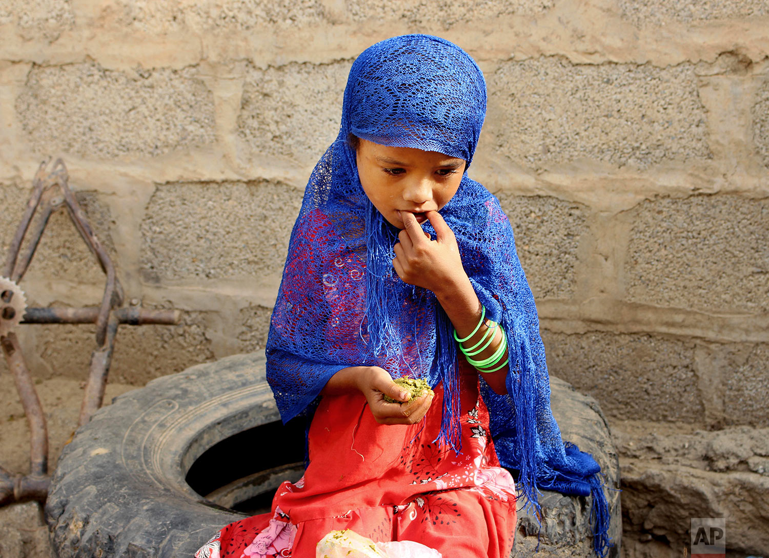 A girl eats boiled leaves from a local vine to stave off starvation, Aug. 25, 2018, in the extremely impoverished district of Aslam, Hajjah, Yemen. (AP Photo/Hammadi Issa)