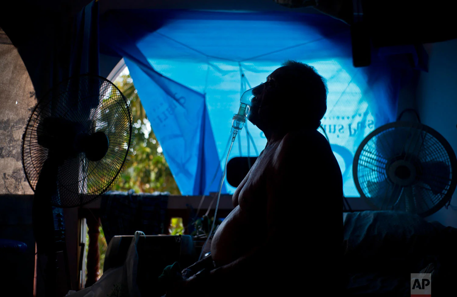 Gilberto Cosme Rodriguez takes one of his 10 a day asthma treatments. Sept. 9, 2018. (AP Photo/Ramon Espinosa)