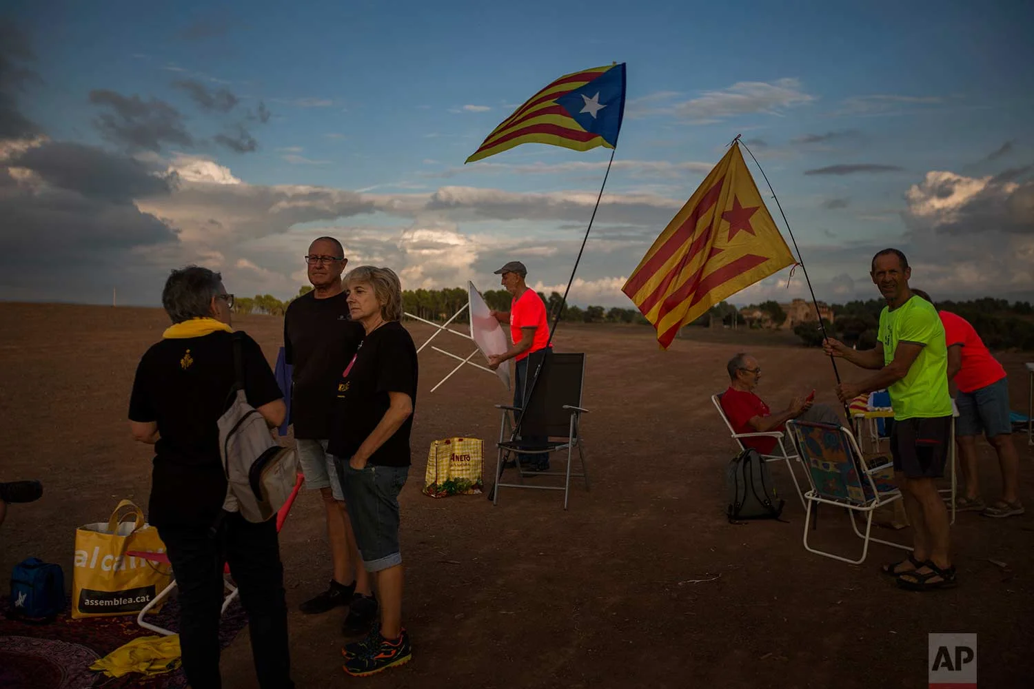 In this Tuesday, Sept. 18, 2018 photo, pro independence supporters set their chairs and tables to make a picnic on a field overlooking the Lledoners prison in Sant Joan de Vilatorrada, about 50 kilometres away from Barcelona, Spain. (AP Photo/Emilio Morenatti)