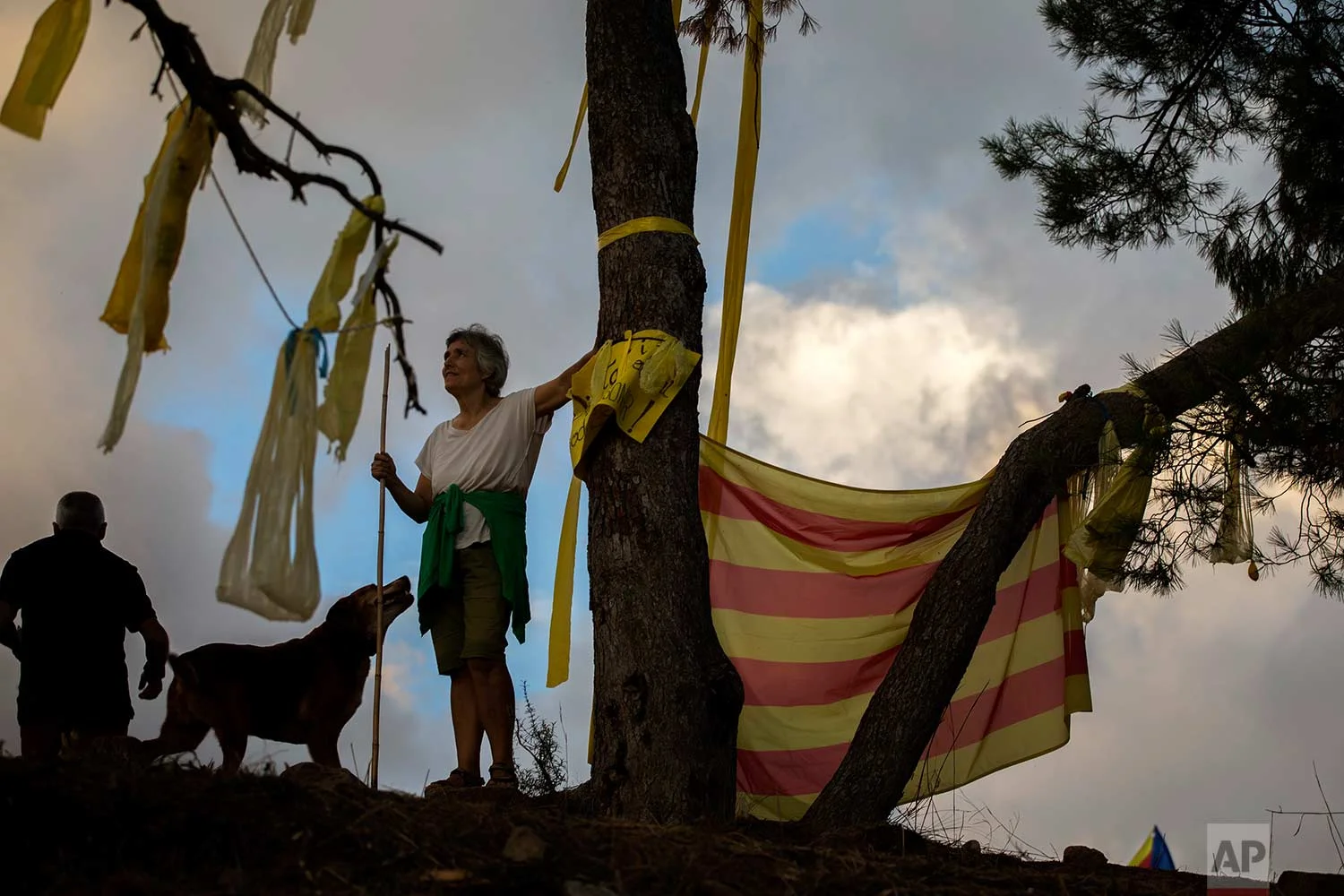 In this Tuesday, Sept. 18, 2018 photo, pro independence people arrive on a hill overlooking the Lledoners prison, in Sant Joan de Vilatorrada, about 50 kilometres away from Barcelona, Spain. (AP Photo/Emilio Morenatti)