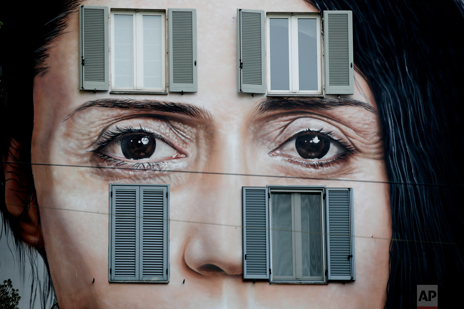  A mural depicting performance artist Marina Abramovic by Italian artist Maurizio Cattellan to publicize his upcoming exhibition The Artist is Present in Shanghai, China, is displayed on a facade of a building in Milan, Italy, Wednesday, Sept. 19, 20