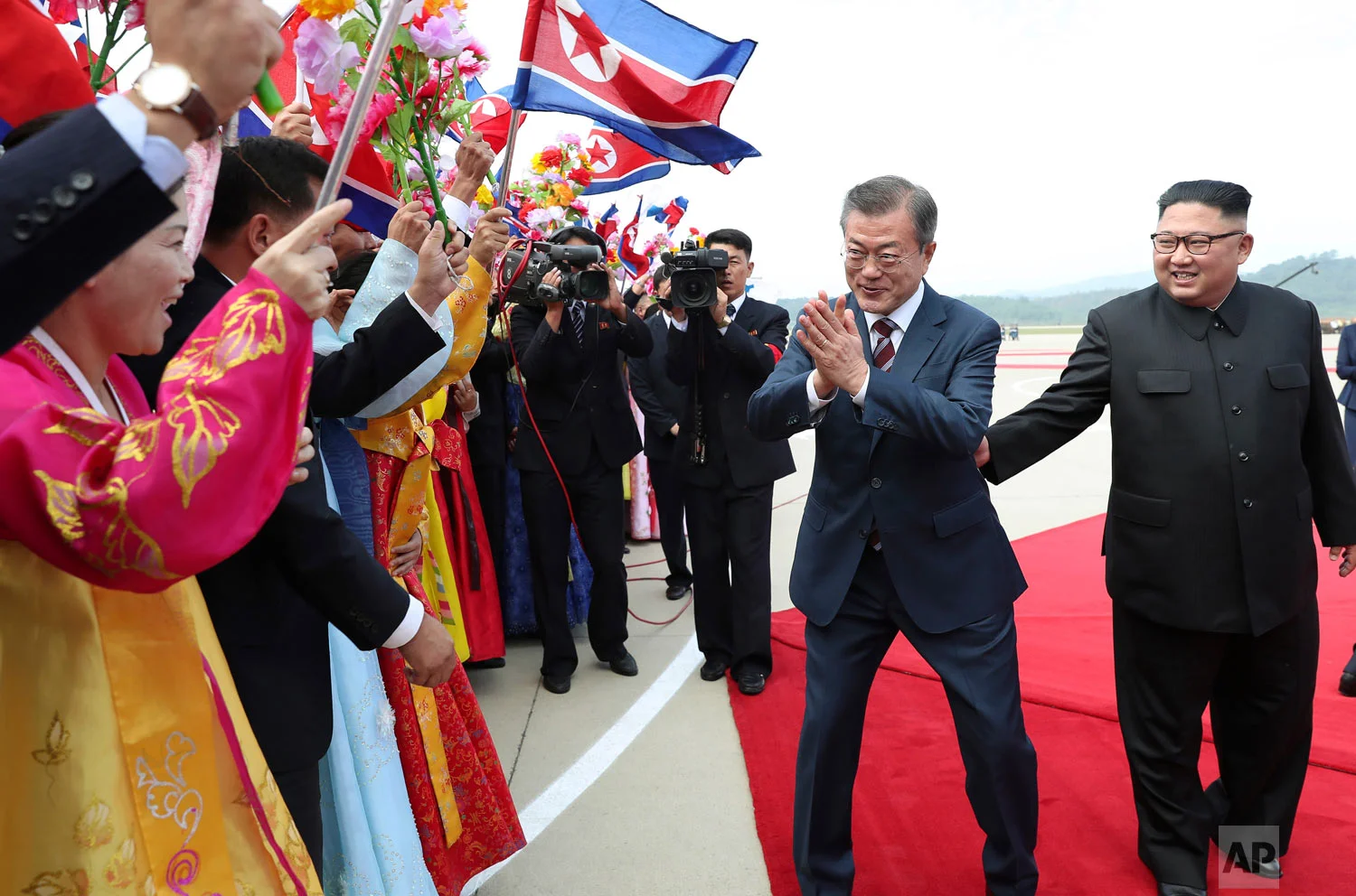 South Korean President Moon Jae-in, second from right, is greeted by North Koreans as North Korean leader Kim Jong Un, right, watches during a welcome ceremony at Sunan International Airport in Pyongyang, North Korea, Tuesday, Sept. 18, 2018. The leaders announced a wide range of agreements which they said were a major step toward peace on the Korean Peninsula. (Pyongyang Press Corps Pool via AP)