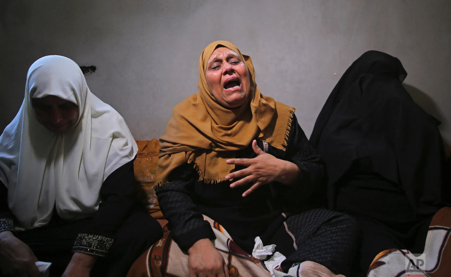 The mother of Ahamd Omar, 20, mourns while waiting with relatives for the body of her son at the family's house during his funeral in the Shati refugee camp, Sept. 19, 2018. (AP Photo/Adel Hana)