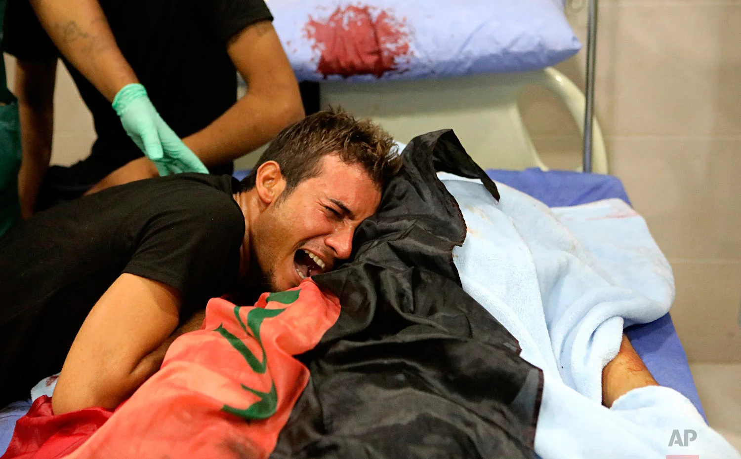 A relative mourns over the body of Ali Qassim, killed during a protest, Sept. 4, 2018, in Basra, 340 miles (550 kilometers) southeast of Baghdad, Iraq. (AP Photo/Nabil al-Jurani)