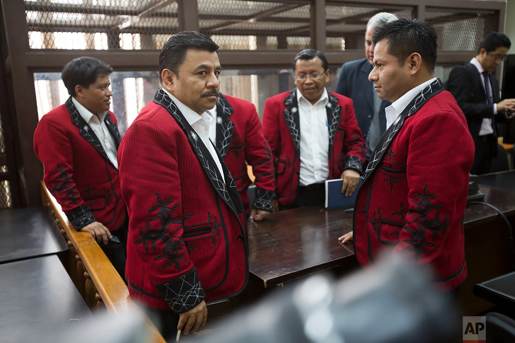 Lawyer Edgar Perez Archila, second from left, and his coworkers, representing the Ixil population and wearing traditional jackets, stand in the courtroom during the last hearing of the former director of military intelligence, Jose Rodriguez Sanchez in Guatemala City, Sept. 26, 2018. Rodriguez Sanchez awaits a new sentence for the crime of genocide, for which he was previously tried along with the late former dictator Efrain Rios Montt in 2013. (AP Photo/Moises Castillo)