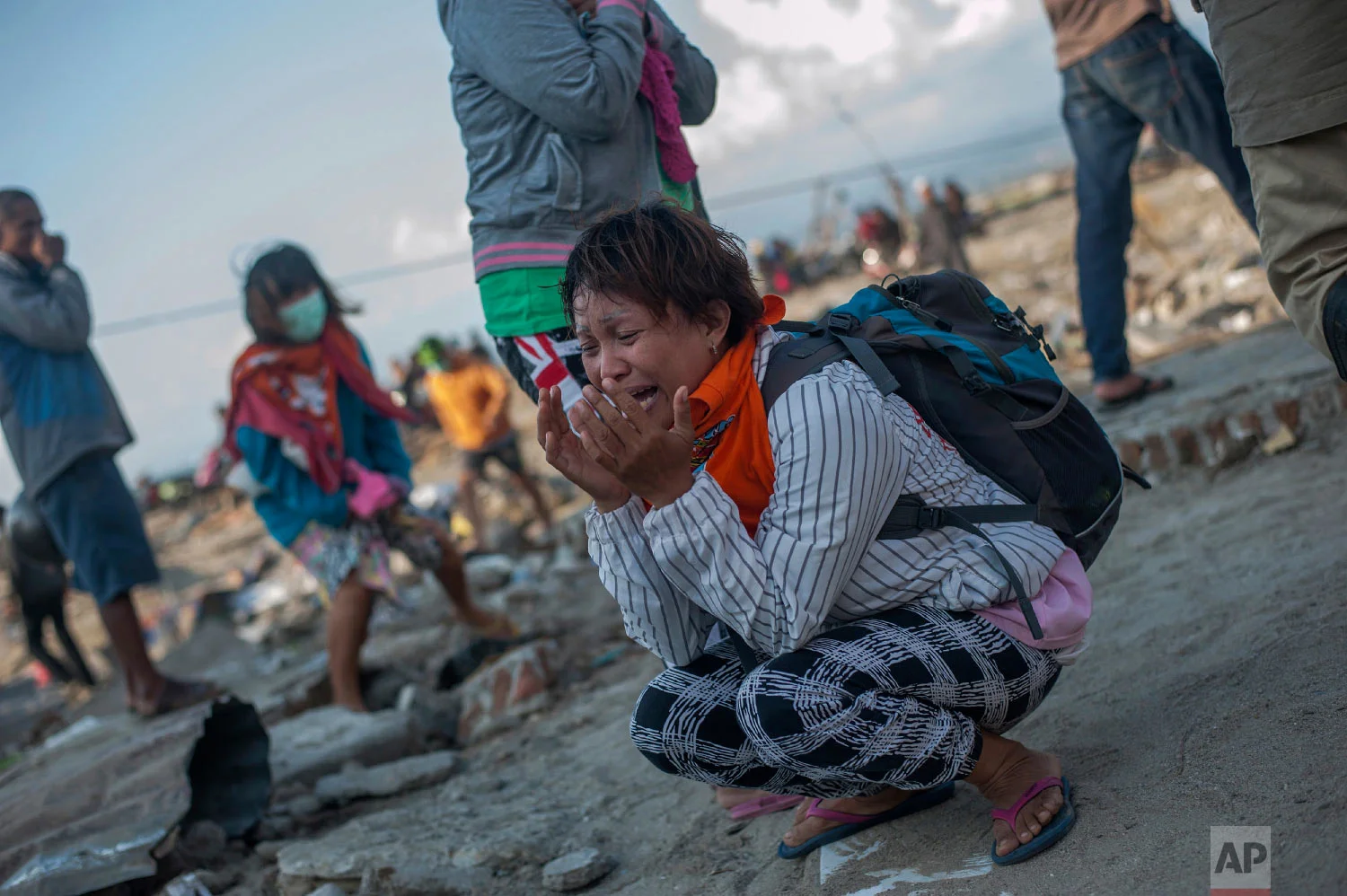Residents react as rescuers recover the body of a tsunami victim in a village heavily damaged by Friday's tsunami in Palu, Central Sulawesi, Indonesia Indonesia, Oct. 3, 2018. (AP Photo/Fauzy Chaniago)