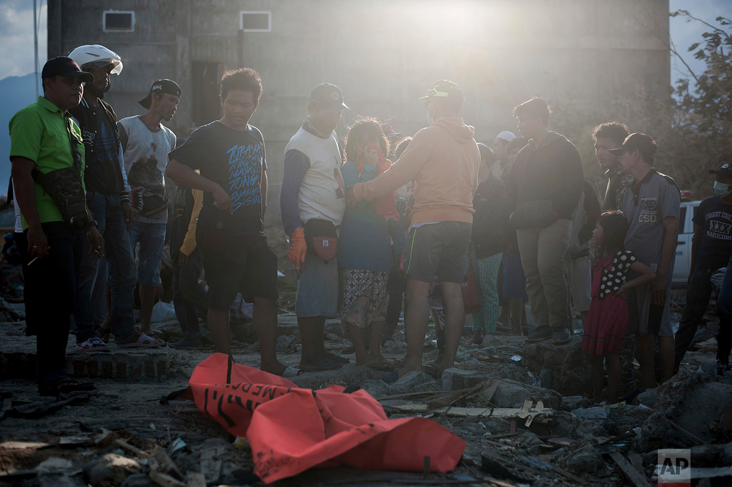 Residents react as they recover the body of a tsunami victim at a village heavily damaged by Friday's tsunami in Palu, Central Sulawesi, Indonesia Indonesia, Oct. 3, 2018. (AP Photo/Fauzy Chaniago)