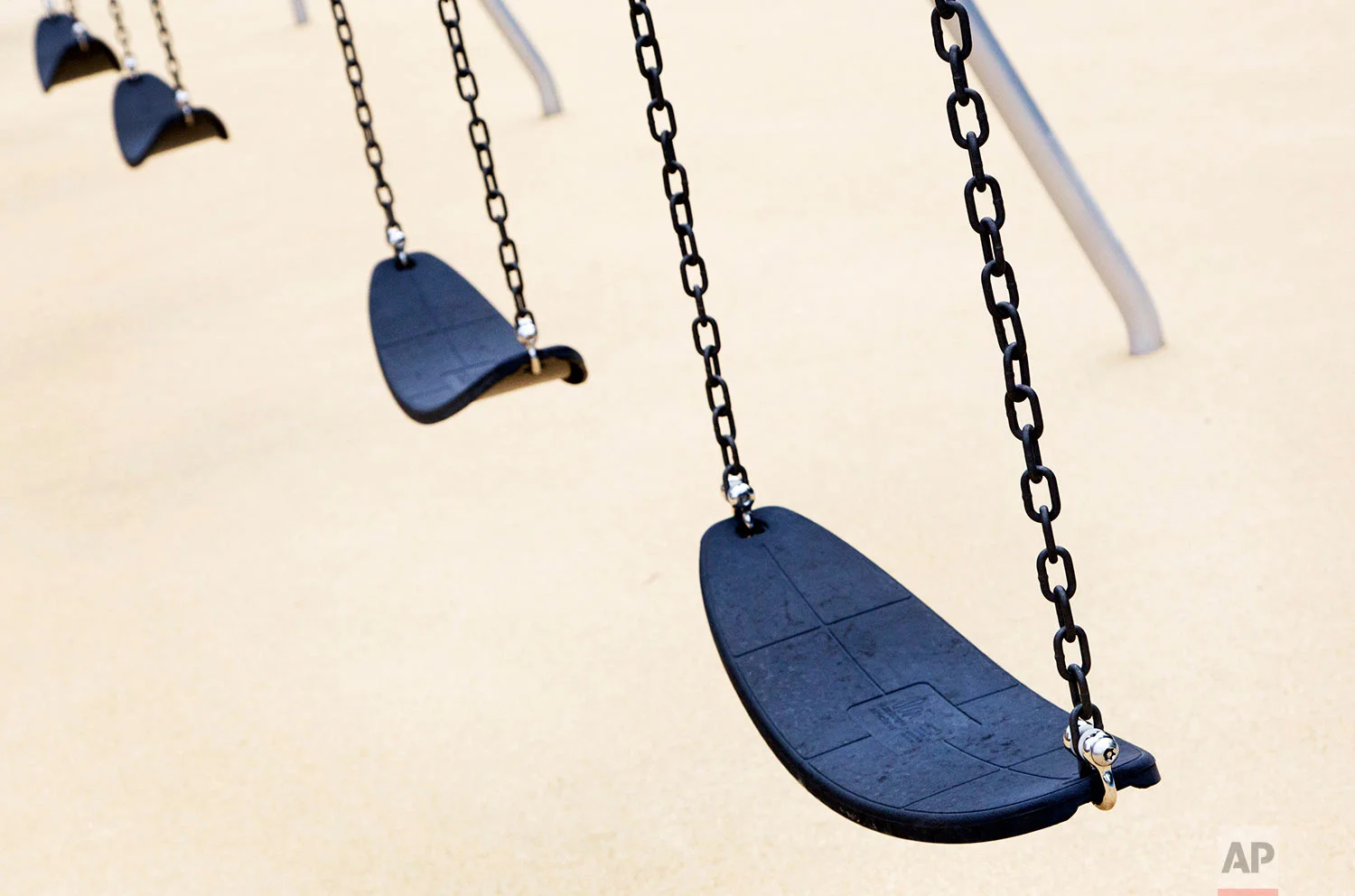 Empty playground swings are in place at the new Sandy Hook Elementary School, July 29, 2016, in Newtown, Conn. (AP Photo/Mark Lennihan)
