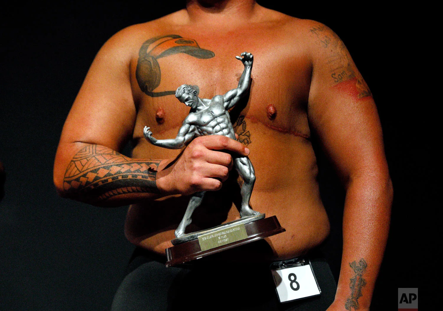 Kennedy Conners, of Conyers, Ga., who transitioned from female a year and half ago, holds his trophy after winning the heavyweight class in the International Association of Trans Bodybuilders competition in Atlanta, Oct. 6, 2018. (AP Photo/David Goldman)