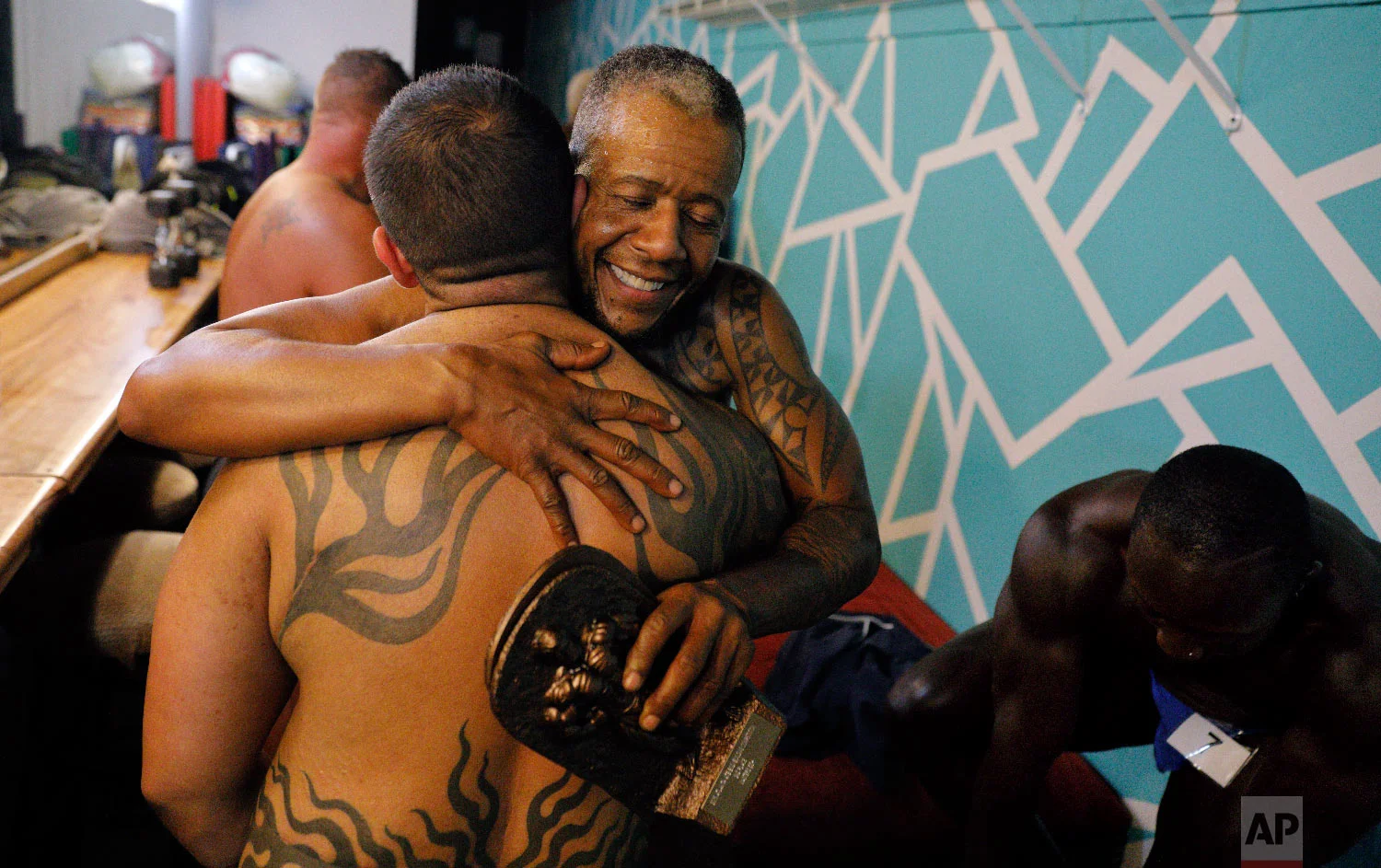 Charles Bennett, of San Francisco, center right, hugs Jai De Lotto, of Richmond, Calif., after they perform at the International Association of Trans Bodybuilders competition in Atlanta, Oct. 6, 2018. (AP Photo/David Goldman)