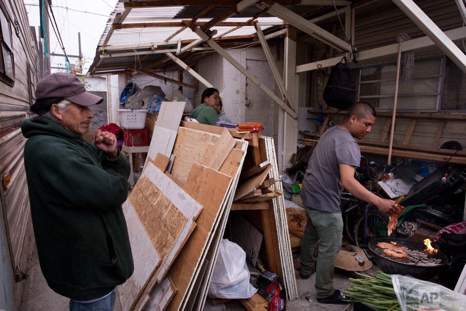 A group of strawberry pickers from Mexico prepare dinner outside their mobile home in Salinas, Calif., Sept. 4, 2018. (AP Photo/Jae C. Hong)