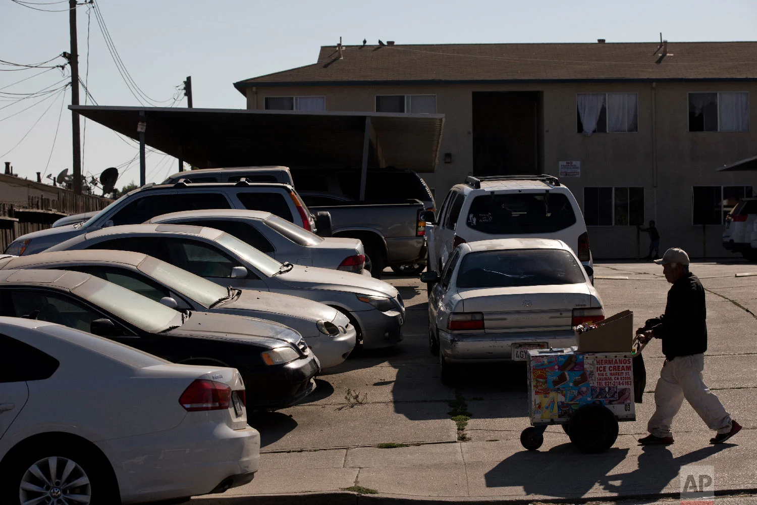 Cars are double-parked in the parking lot of an apartment complex in Salinas, Calif., Sept. 6, 2018. (AP Photo/Jae C. Hong)
