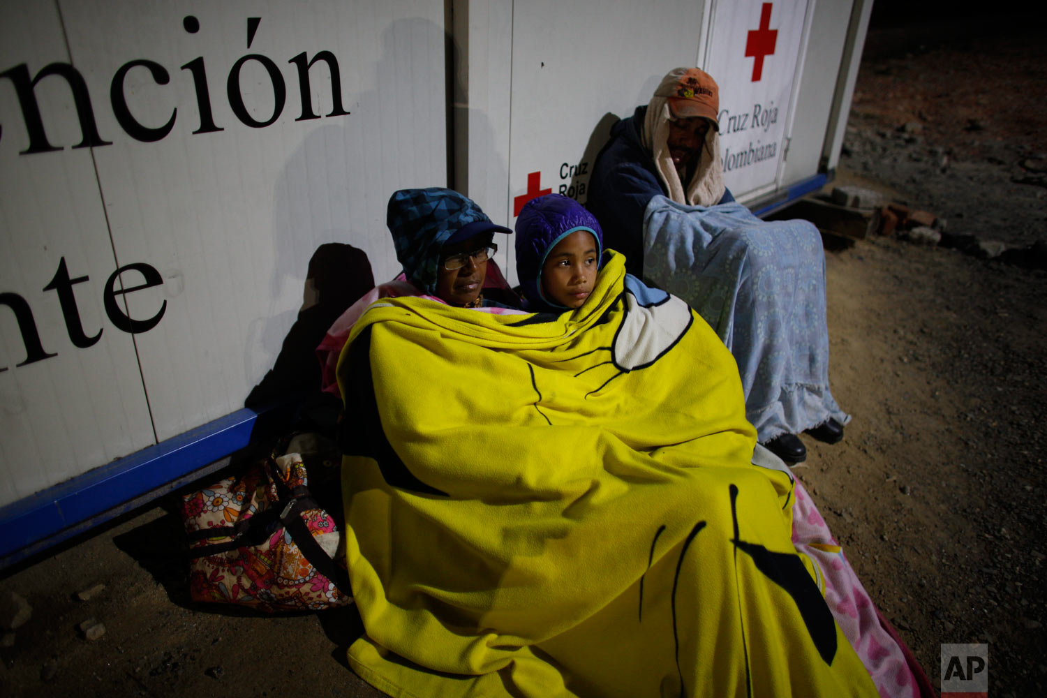  In this Aug. 31, 2018 photo, Venezuelan Sandra Cadiz rests with her 10-year-old daughter Angelis on a dirt floor near a gas station in Pamplona, Colombia, on their journey to Peru. Cadiz took out her life savings in Venezuelan bolivars for the trip,