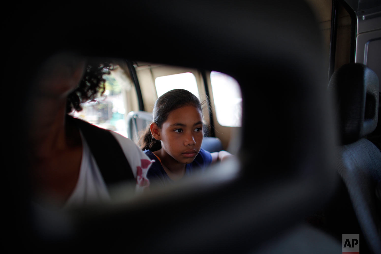  In this Sept. 2, 2018 photo, 10-year-old Venezuelan Angelis sits in a car with her mother Sandra Cadiz as they get a free ride from a driver to the next city, Lebrija, Colombia, on their journey to Peru. A police officer offered to hail down a ride,