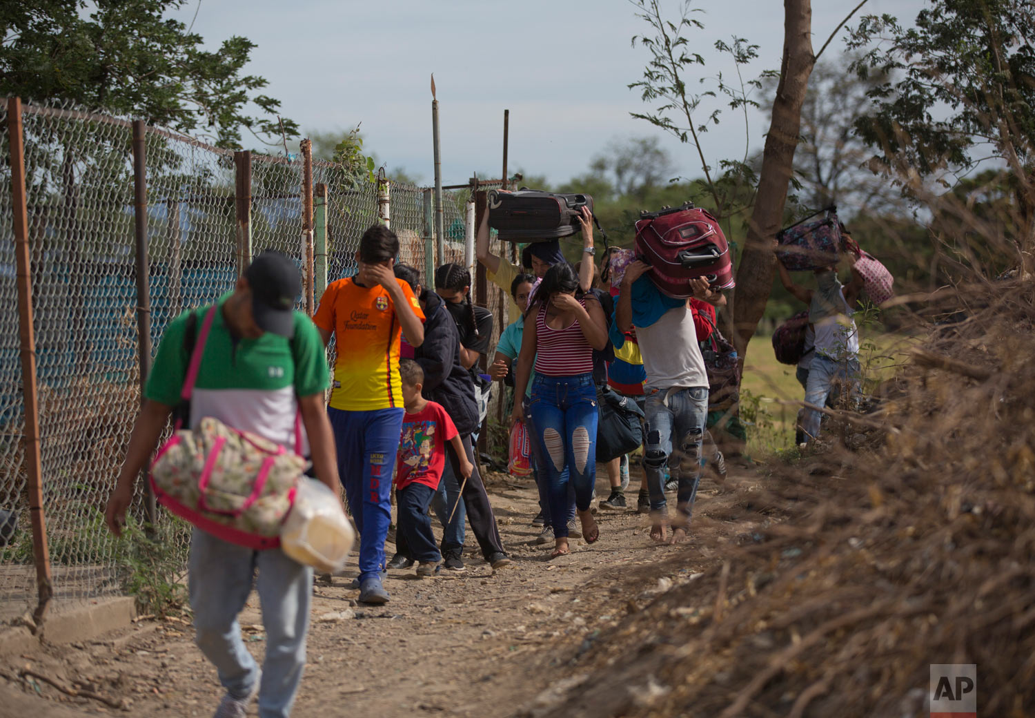  In this Aug. 31, 2018 photo, Venezuelans illegally cross into Colombia, to Villa del Rosario, along a path known as a "trocha." Uncontrolled by Venezuelan or Colombian authorities, the trochas are ruled by bands of armed men sporting rifles and dres