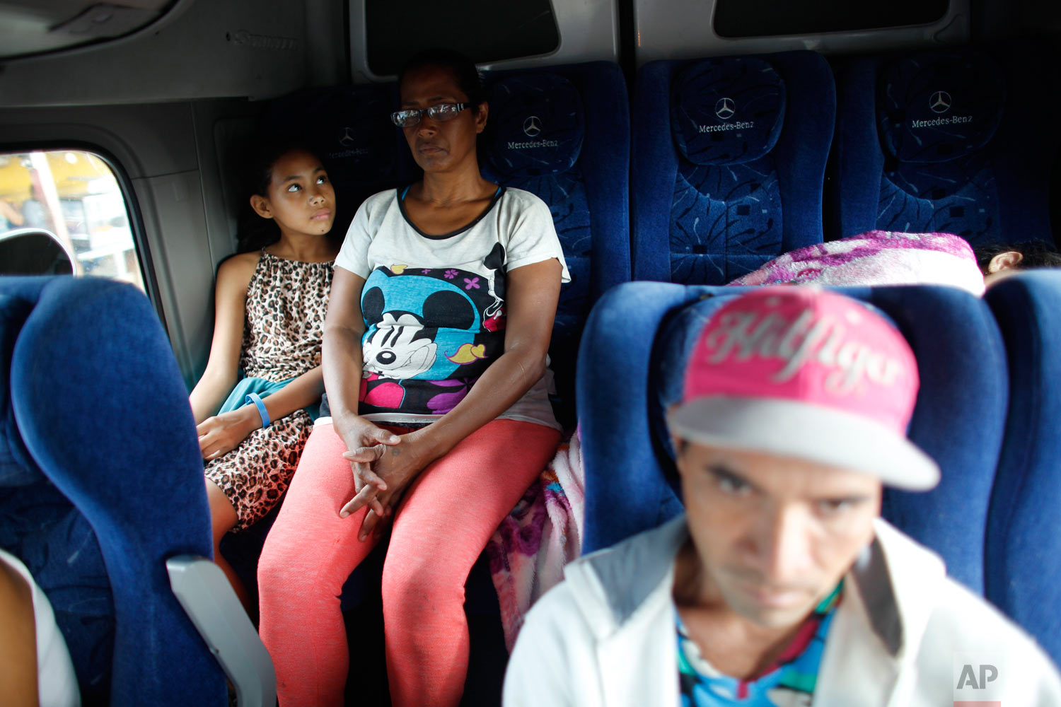  In this Sept. 4, 2018 photo, 10-year-old Venezuelan Angelis looks up at her mother Sandra Cadiz on the back of a bus at the stop in San Juan de la Paz, Colombia, on their journey to Peru. It was in San Juan De La Paz that Cadiz decided to switch her