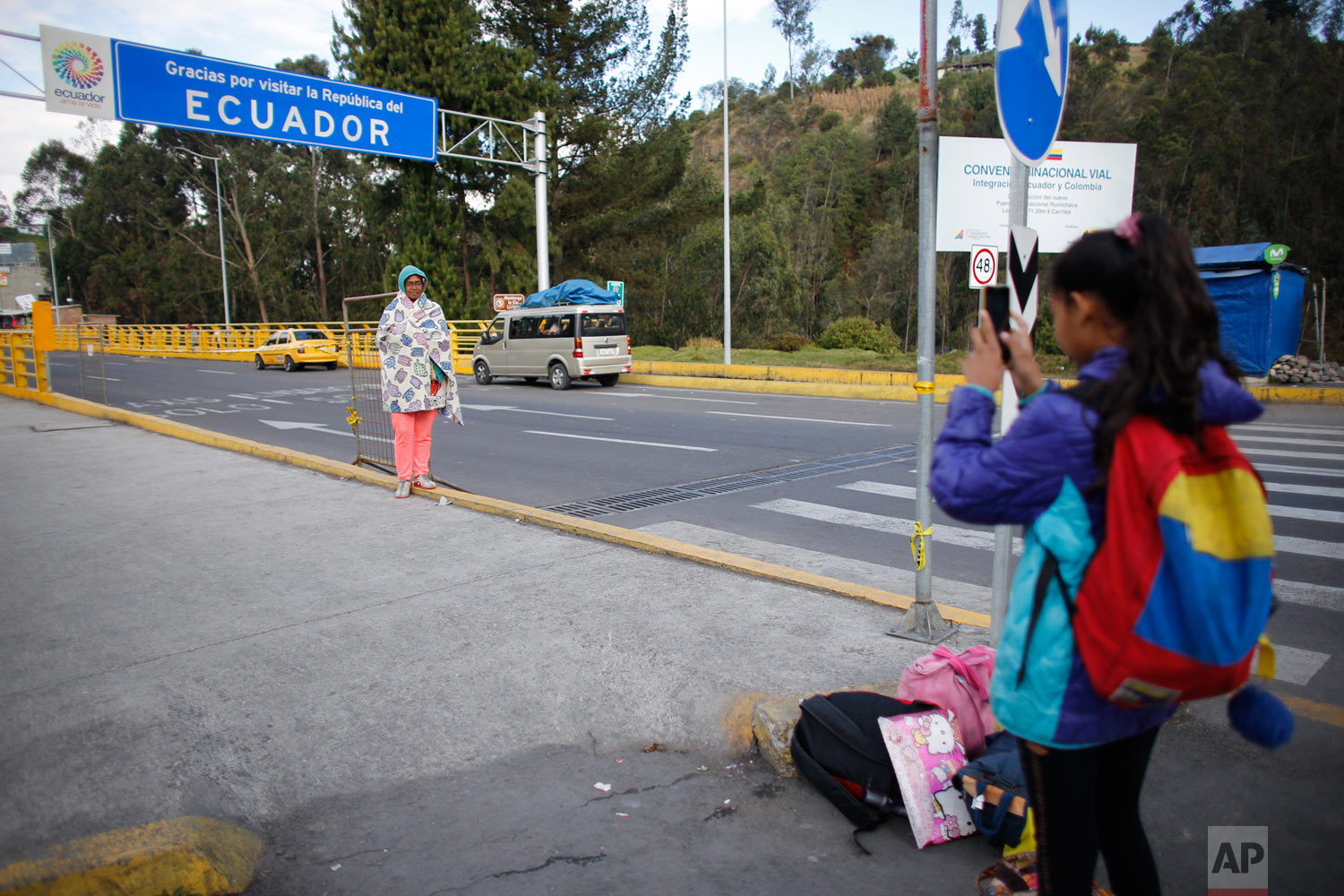  In this Sept. 5, 2018 photo, 10-year-old Venezuelan Angelis takes a picture of her mother Sandra Cadiz after they crossed the Colombian border into Huaquillas, Ecuador, as they journey to Peru. In total they had to go through three separate migratio