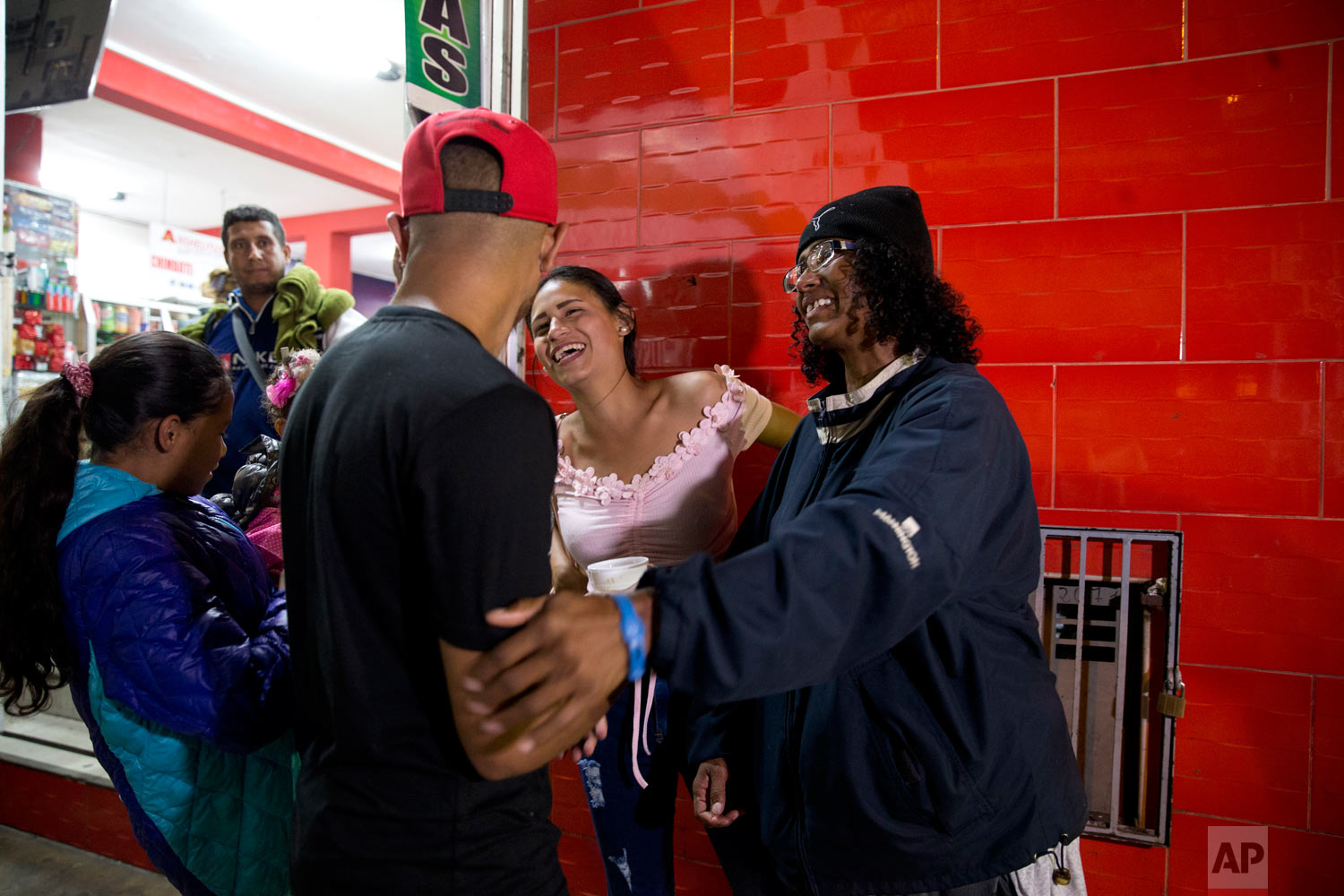  In this Sept. 8, 2018 photo, Sandra Cadiz, right, smiles as she reunites with her son Leonardo, front left, and her daughter-in-law Daniela Gomez, as she and her 10-year-old daughter Angelis, far left, arrive to the bus station in Lima, Peru, after 