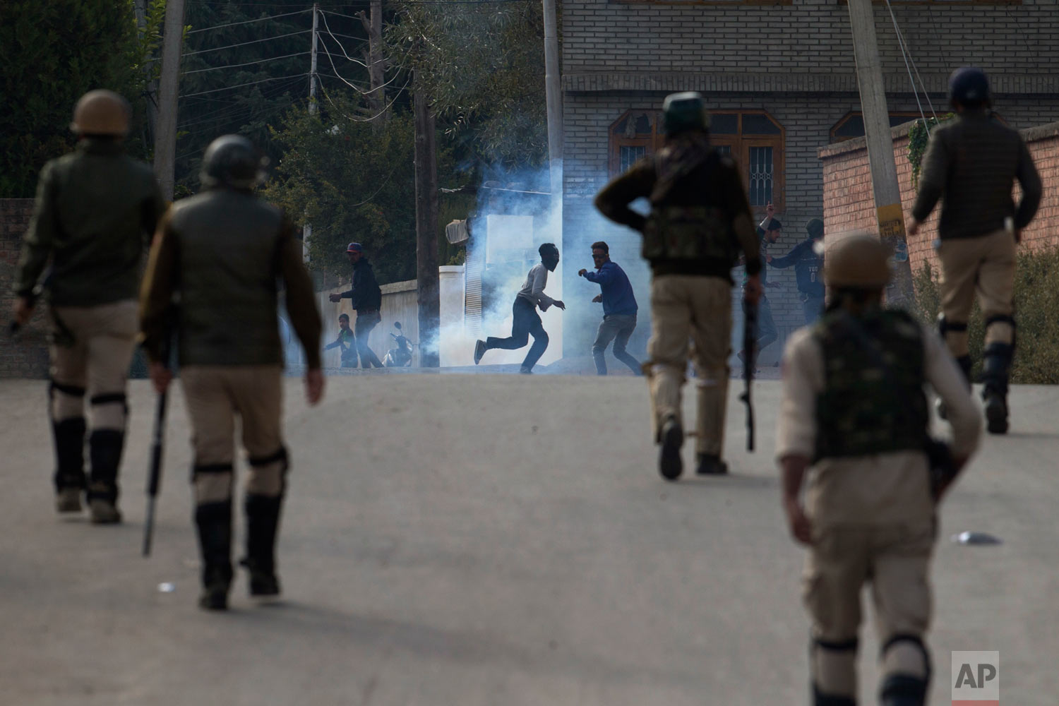  Kashmiri protesters run for cover from a tear gas shell fired at them by Indian security forces in Srinagar, India, Friday, Oct. 19, 2018. Government forces fired tear gas and pellets on Kashmiris who gathered after Friday afternoon prayers on a pro