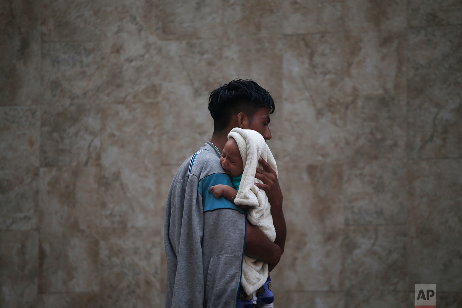  A Central American migrant making their way to the U.S. in a large caravan carries his son after arriving in Tapachula, Mexico, Sunday, Oct. 21, 2018. (AP Photo/Moises Castillo) 