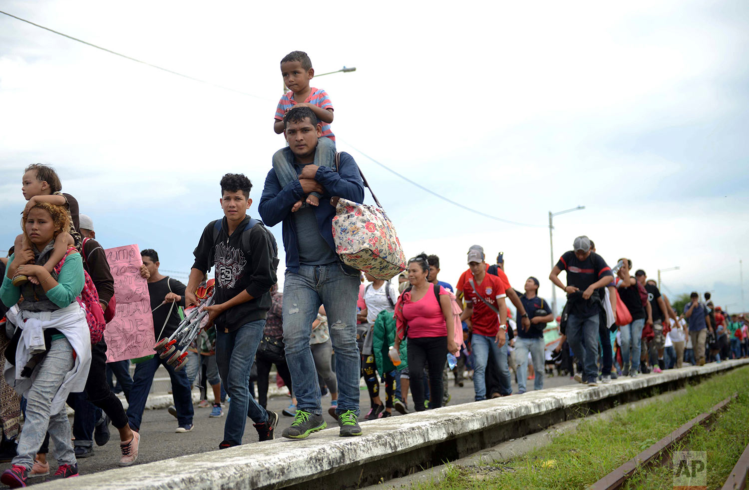  Thousands of Honduran migrants rush across the border towards Mexico, in Tecun Uman, Guatemala, Friday, Oct. 19, 2018. (AP Photo/Oliver de Ros) 