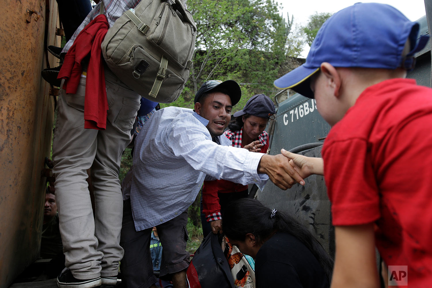  Honduran migrants walking to the U.S. climb on to the space between the cab and bed of a trailer in Zacapa, Guatemala, Wednesday, Oct. 17, 2018. (AP Photo/Moises Castillo) 