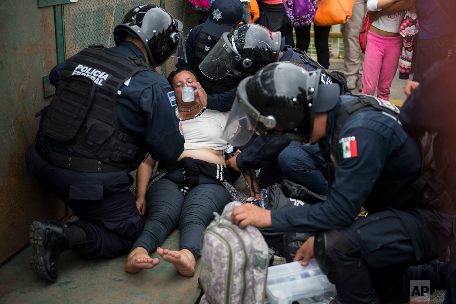  Mexican paramedics help a Honduras migrant woman who fainted after crossing the border between Guatemala and Mexico, in Ciudad Hidalgo, Mexico, Saturday, Oct. 20, 2018.  (AP Photo/Oliver de Ros) 