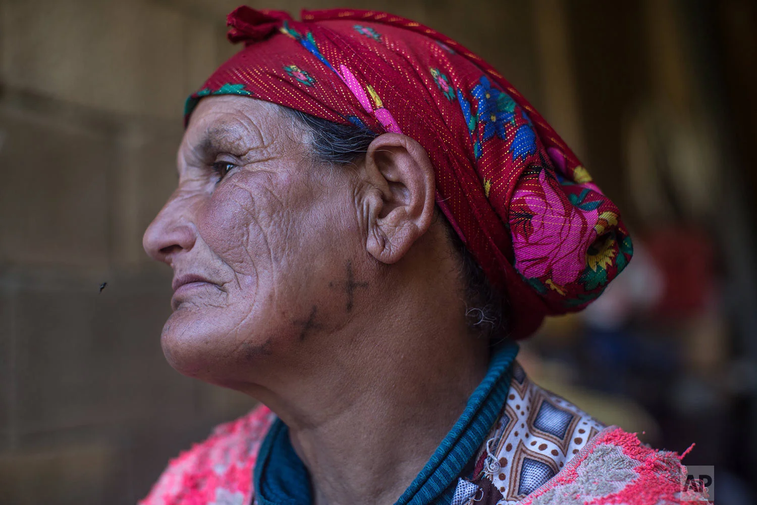 In this Saturday, Oct. 13, 2018 photo, Hano Hamou Youssfi, 65, poses for a portrait displaying her face tattoo, in the Middle Atlas town of Anergui, near Azilal, central Morocco. (AP Photo/Mosa'ab Elshamy)