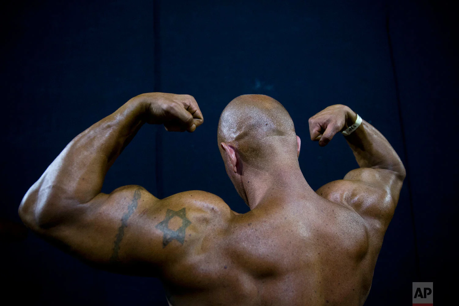 A contestant exercises backstage during the National Amateur Body Builders' Association competition in Tel Aviv, Israel on Oct. 18, 2018. (AP Photo/Oded Balilty)